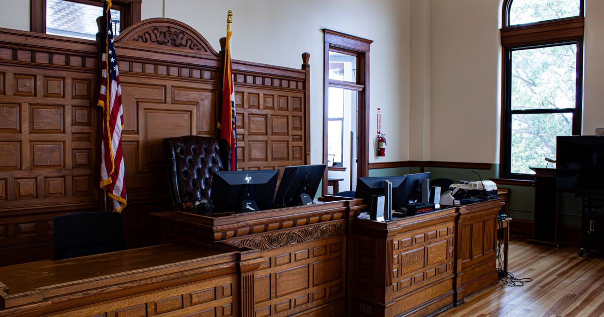 Empty courtroom with the judge's bench and flags.