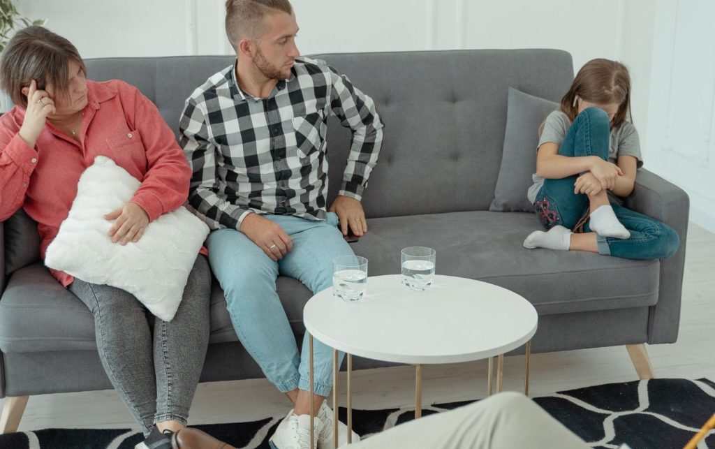 Family seated together on a couch during a counseling discussion