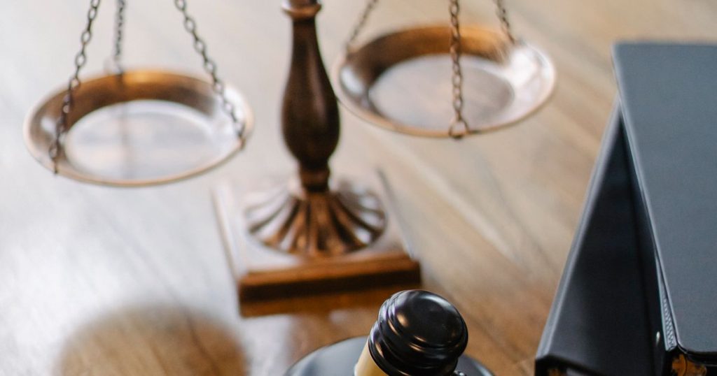 Scales of justice and a gavel on a wooden desk