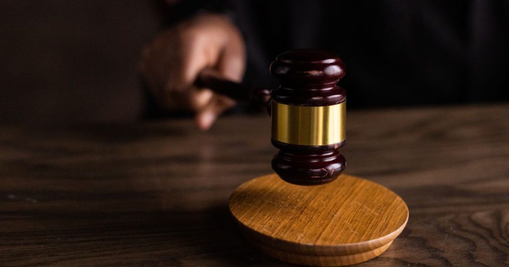 Wooden gavel striking a sound block on a courtroom desk
