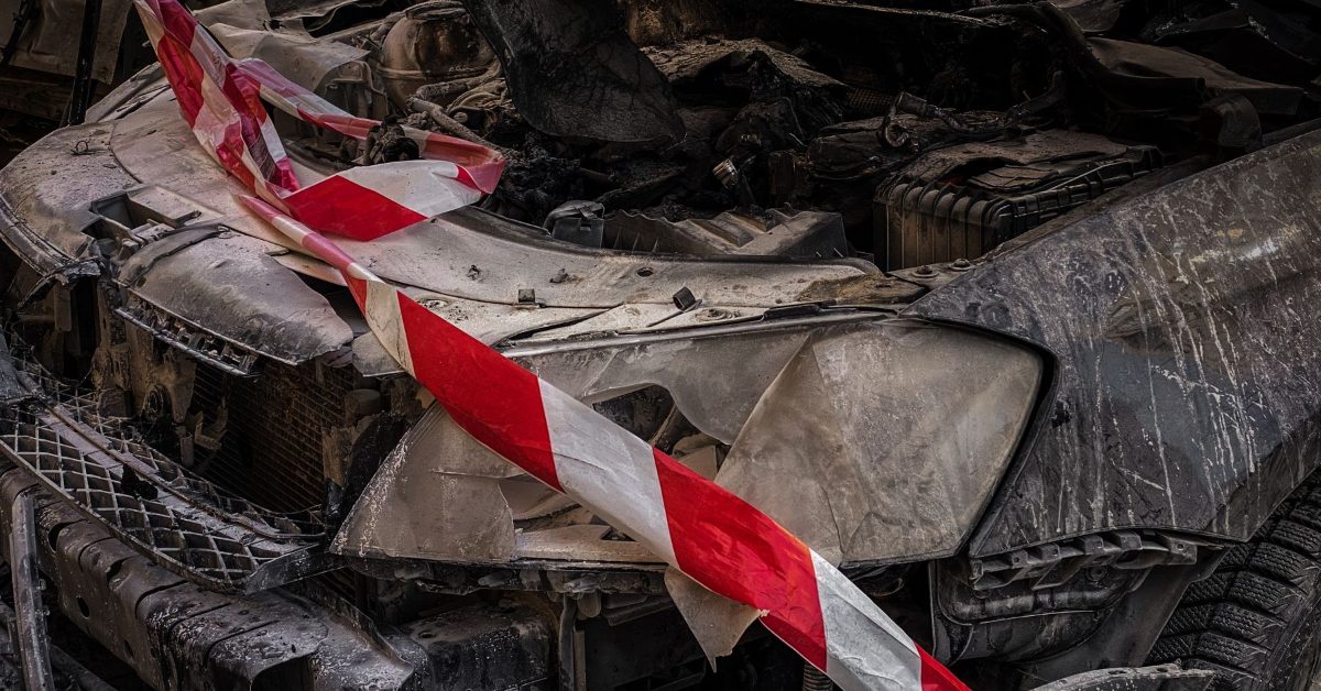 Wrecked car marked with safety tape after a crash